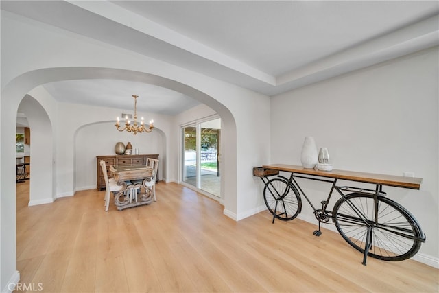 hall with light hardwood / wood-style flooring and a chandelier