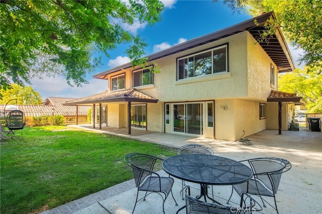 rear view of property featuring a yard and a patio