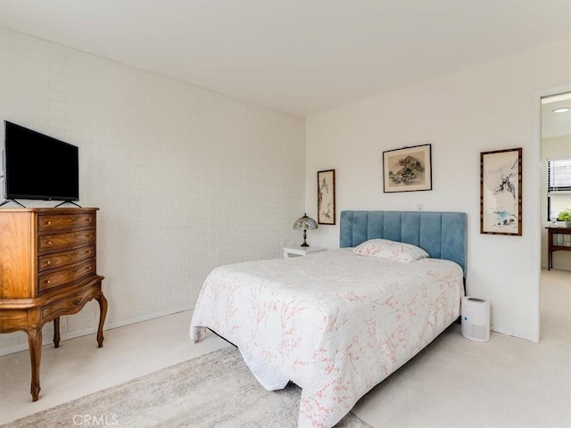 bedroom with carpet and brick wall