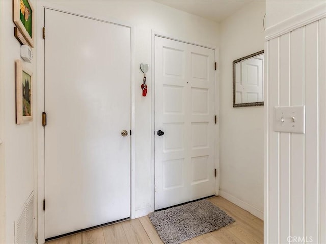 interior space featuring baseboards, visible vents, and light wood-style floors