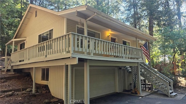 exterior space with a garage, stairs, and aphalt driveway