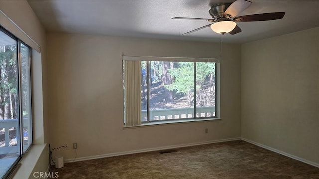carpeted spare room with baseboards and a ceiling fan