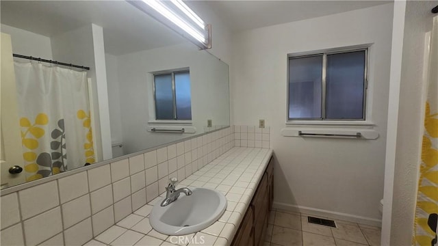 bathroom featuring toilet, vanity, baseboards, and tile patterned flooring