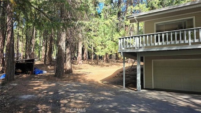 view of yard featuring an attached garage and aphalt driveway