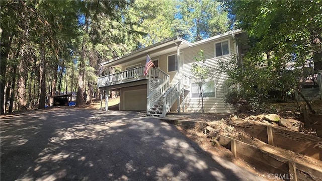 view of front of house featuring an attached garage, driveway, and stairs