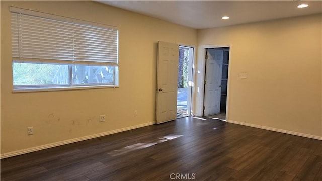 spare room with wood finished floors, baseboards, and recessed lighting