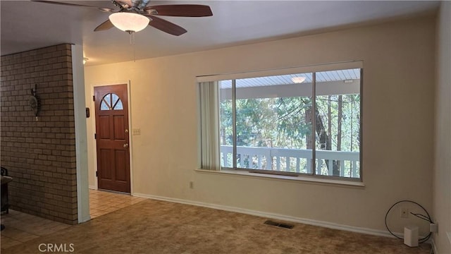 foyer with carpet flooring, baseboards, a ceiling fan, and visible vents