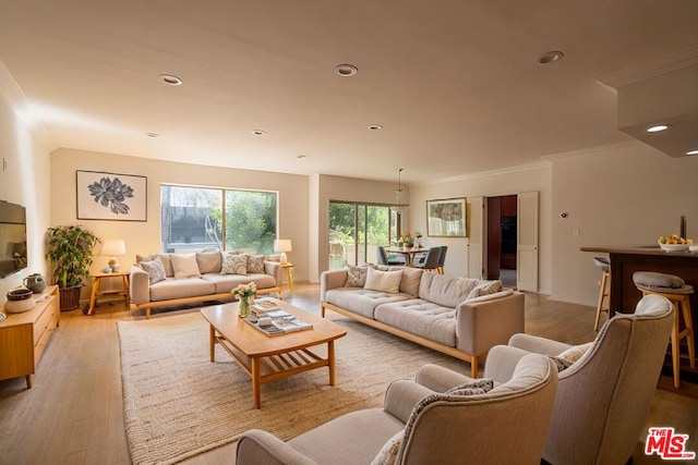 living room with light wood-type flooring and ornamental molding