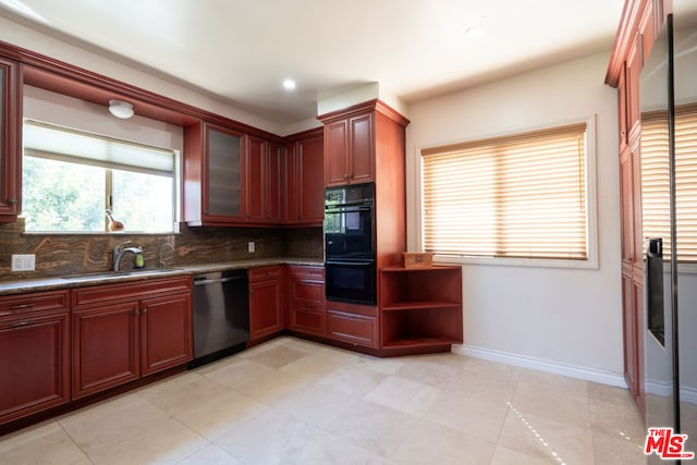 kitchen with backsplash, sink, black double oven, stainless steel dishwasher, and light tile patterned floors