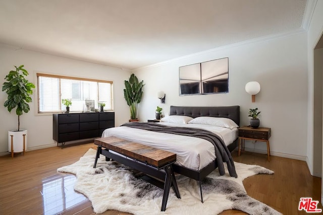 bedroom featuring crown molding and light hardwood / wood-style floors