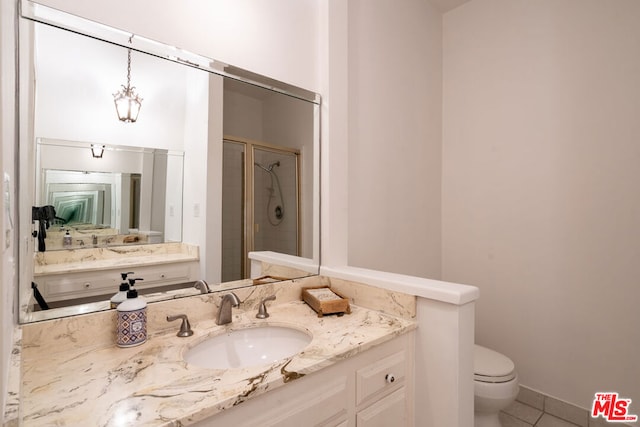 bathroom with tile patterned floors, toilet, vanity, and walk in shower