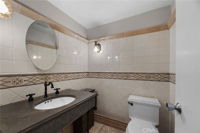 bathroom with toilet, sink, and tile walls