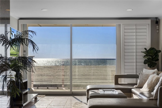 interior space featuring crown molding, a water view, and light tile patterned floors