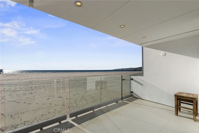 balcony with a water view and a beach view