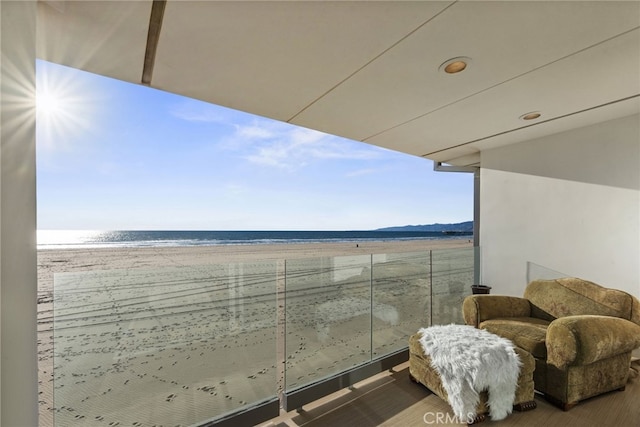 balcony featuring a water view and a view of the beach