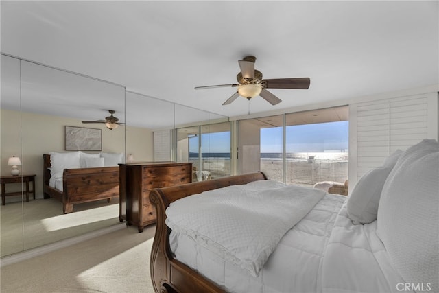 carpeted bedroom featuring ceiling fan, expansive windows, and access to outside