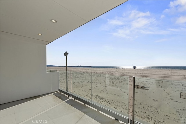 balcony with a water view and a beach view