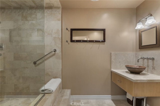 bathroom with a tile shower and vanity