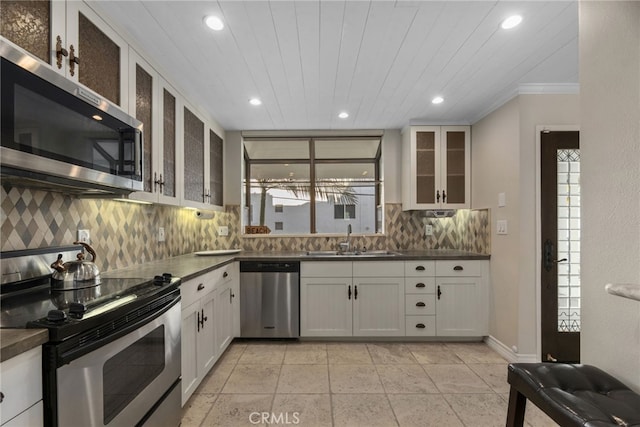 kitchen with white cabinets, backsplash, sink, and stainless steel appliances