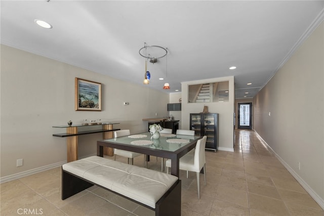 dining area with crown molding and light tile patterned flooring