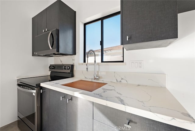 kitchen with light stone counters, sink, and stainless steel electric range