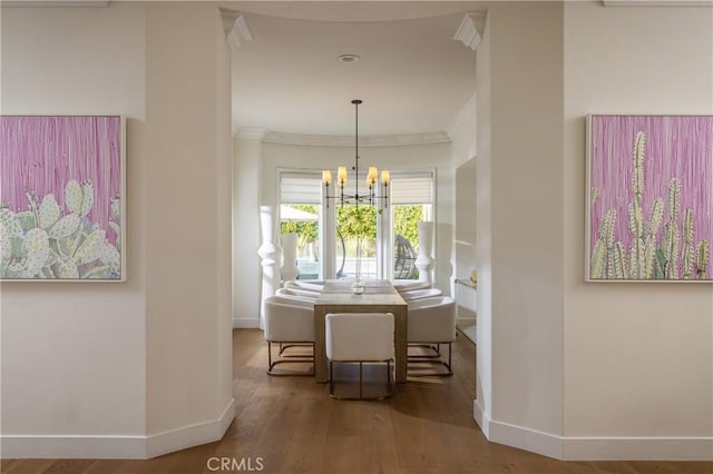 dining room with hardwood / wood-style flooring, a notable chandelier, and ornamental molding