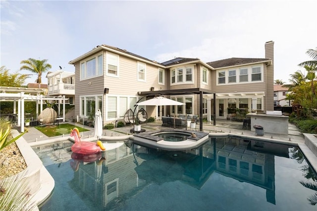 back of house with a swimming pool with hot tub and a patio