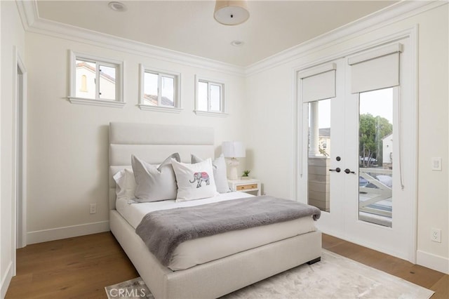 bedroom with hardwood / wood-style flooring, access to exterior, and multiple windows