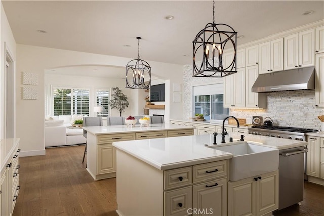 kitchen featuring a kitchen island with sink, hanging light fixtures, and dark hardwood / wood-style floors