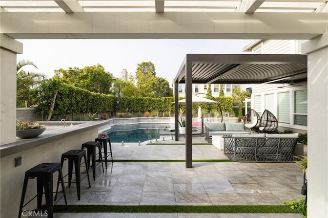 view of swimming pool with exterior bar, an outdoor hangout area, a patio, and a pergola