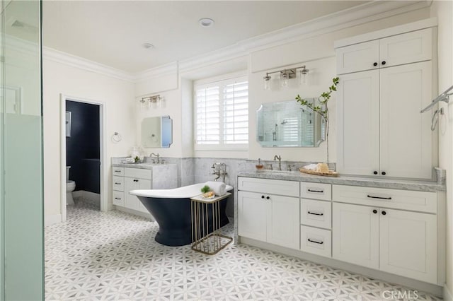 full bathroom featuring separate shower and tub, toilet, vanity, and ornamental molding