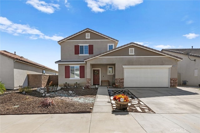 traditional-style house with driveway, brick siding, an attached garage, and stucco siding