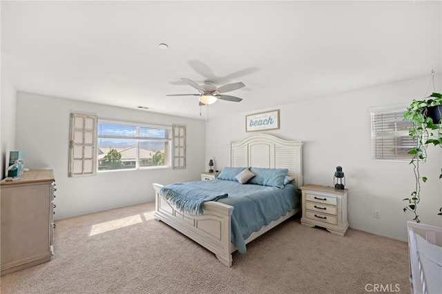 bedroom featuring a ceiling fan, light colored carpet, and visible vents