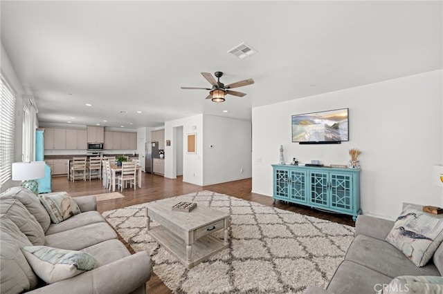 living area with a ceiling fan, visible vents, wood finished floors, and recessed lighting