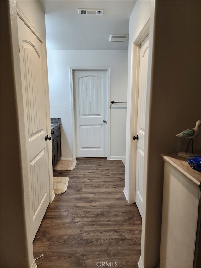 bathroom featuring visible vents, vanity, baseboards, and wood finished floors