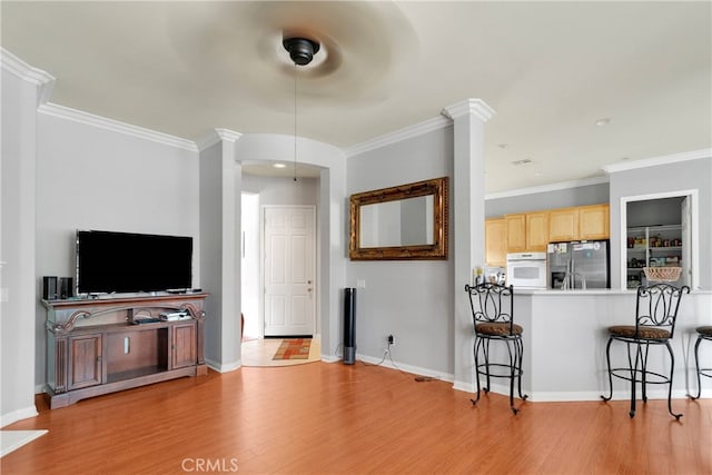 living room with ornamental molding and light wood-type flooring