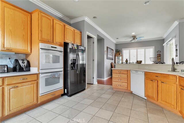 kitchen with white appliances, ornamental molding, and sink