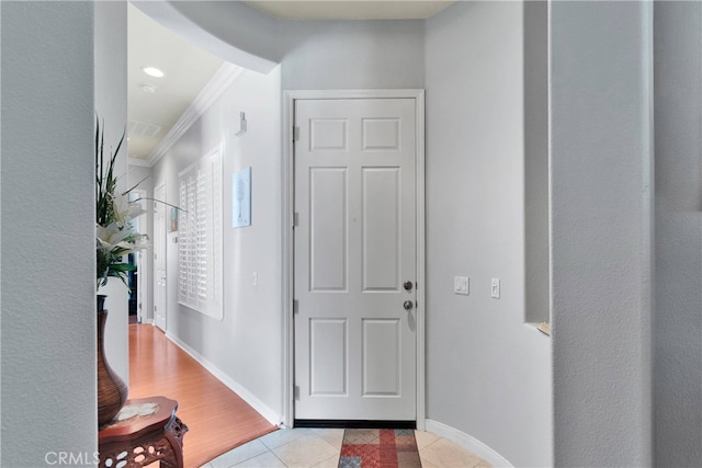 tiled foyer entrance with crown molding