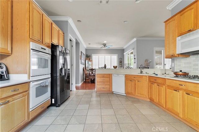 kitchen with appliances with stainless steel finishes, crown molding, and light tile patterned floors