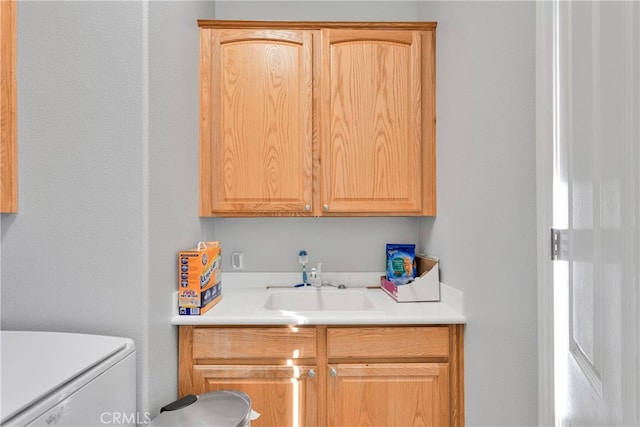 clothes washing area featuring sink and cabinets