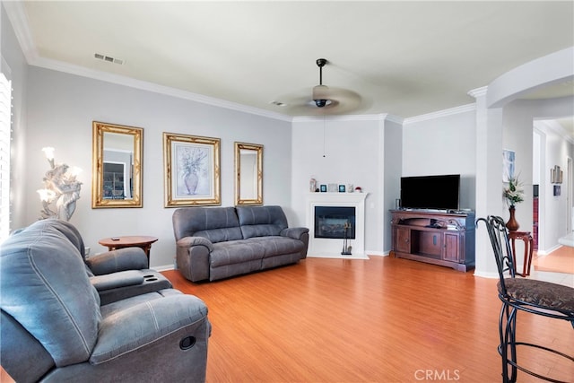 living room featuring ceiling fan, ornamental molding, and hardwood / wood-style floors