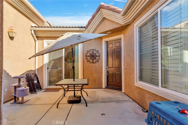 view of exterior entry with a patio area