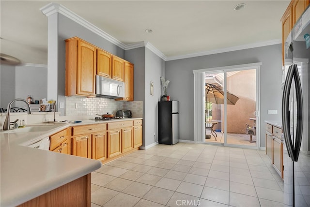 kitchen with sink, decorative backsplash, stainless steel appliances, light tile patterned floors, and ornamental molding