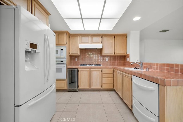 kitchen featuring white appliances, sink, backsplash, tile countertops, and light tile patterned floors