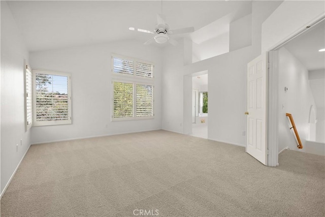 carpeted empty room featuring ceiling fan and high vaulted ceiling