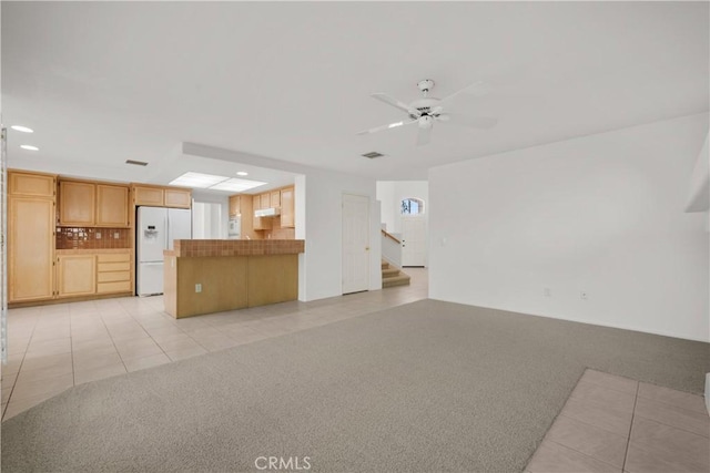 unfurnished living room with ceiling fan and light colored carpet