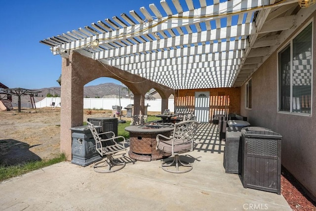 view of patio with a mountain view and an outdoor fire pit