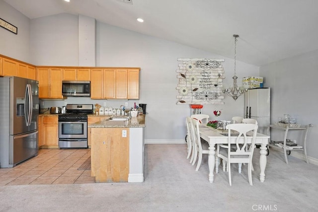 kitchen with pendant lighting, light colored carpet, sink, light stone counters, and stainless steel appliances