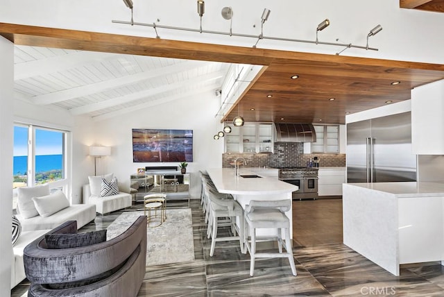 interior space with white cabinetry, tasteful backsplash, sink, lofted ceiling with beams, and high quality appliances