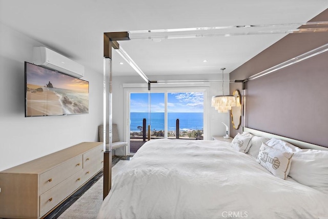 bedroom with access to exterior, a wall mounted AC, and a water view